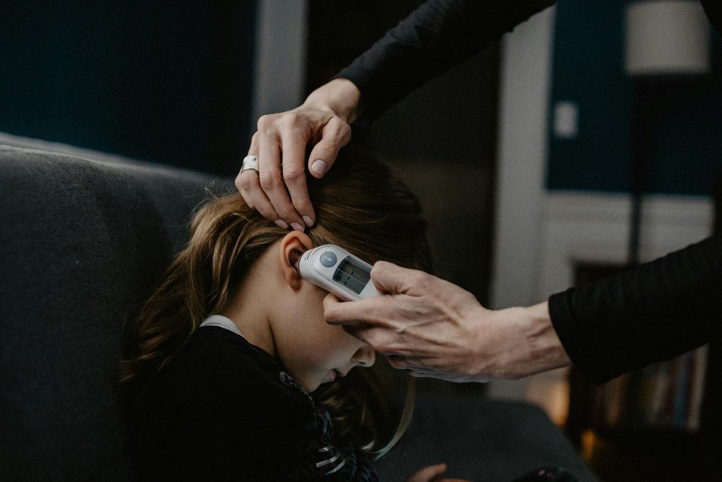 A woman checking her child’s temperature