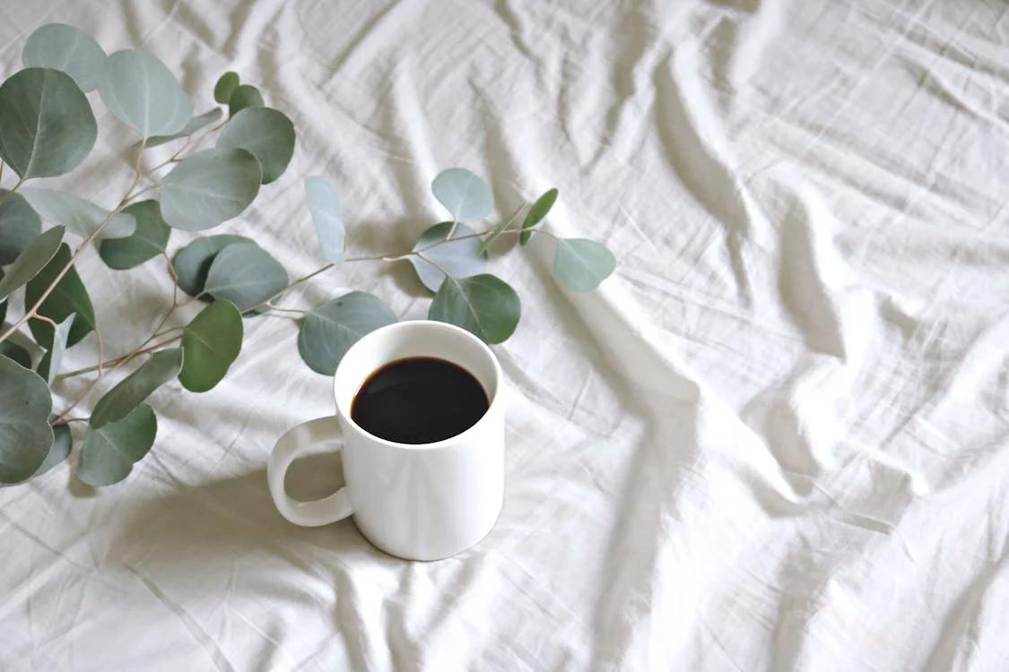 A cup of coffee placed on a bed