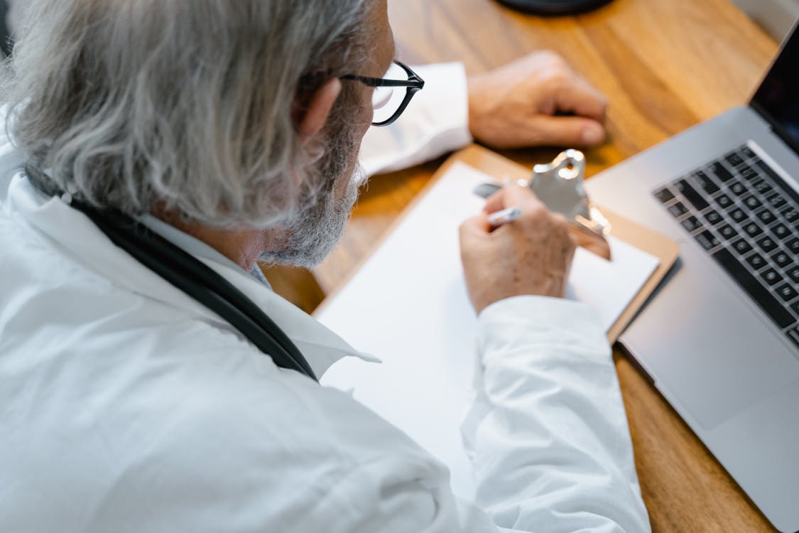 a doctor writing down a note on a clipboard