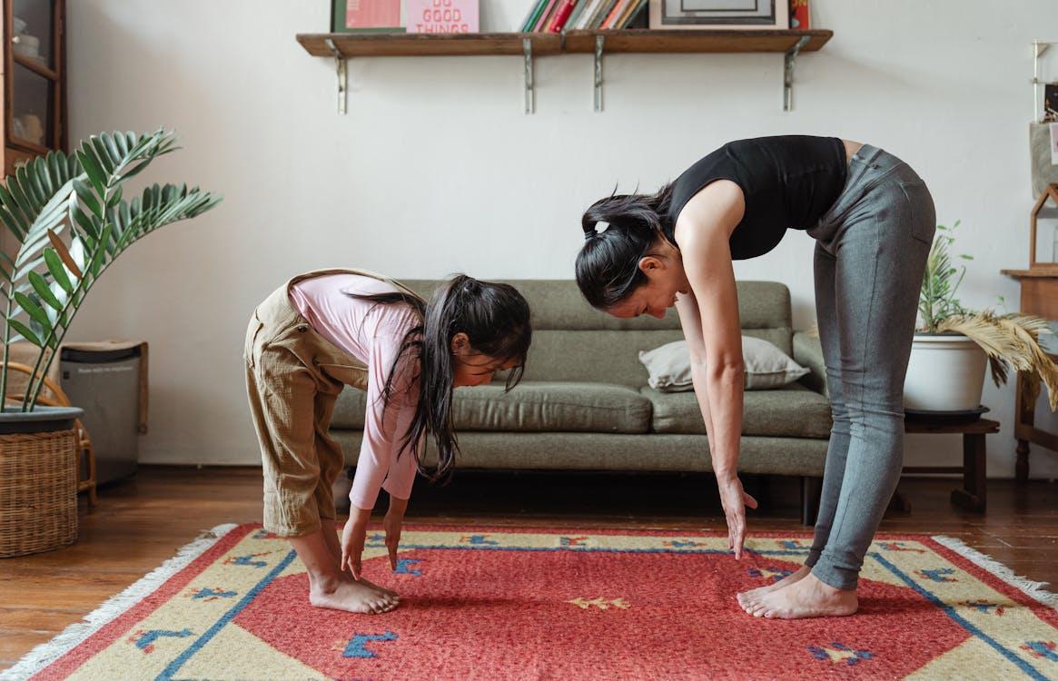 A mother and daughter stretching together for fitness