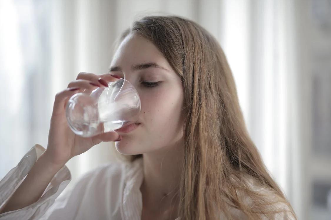 A woman drinking water from a glass 