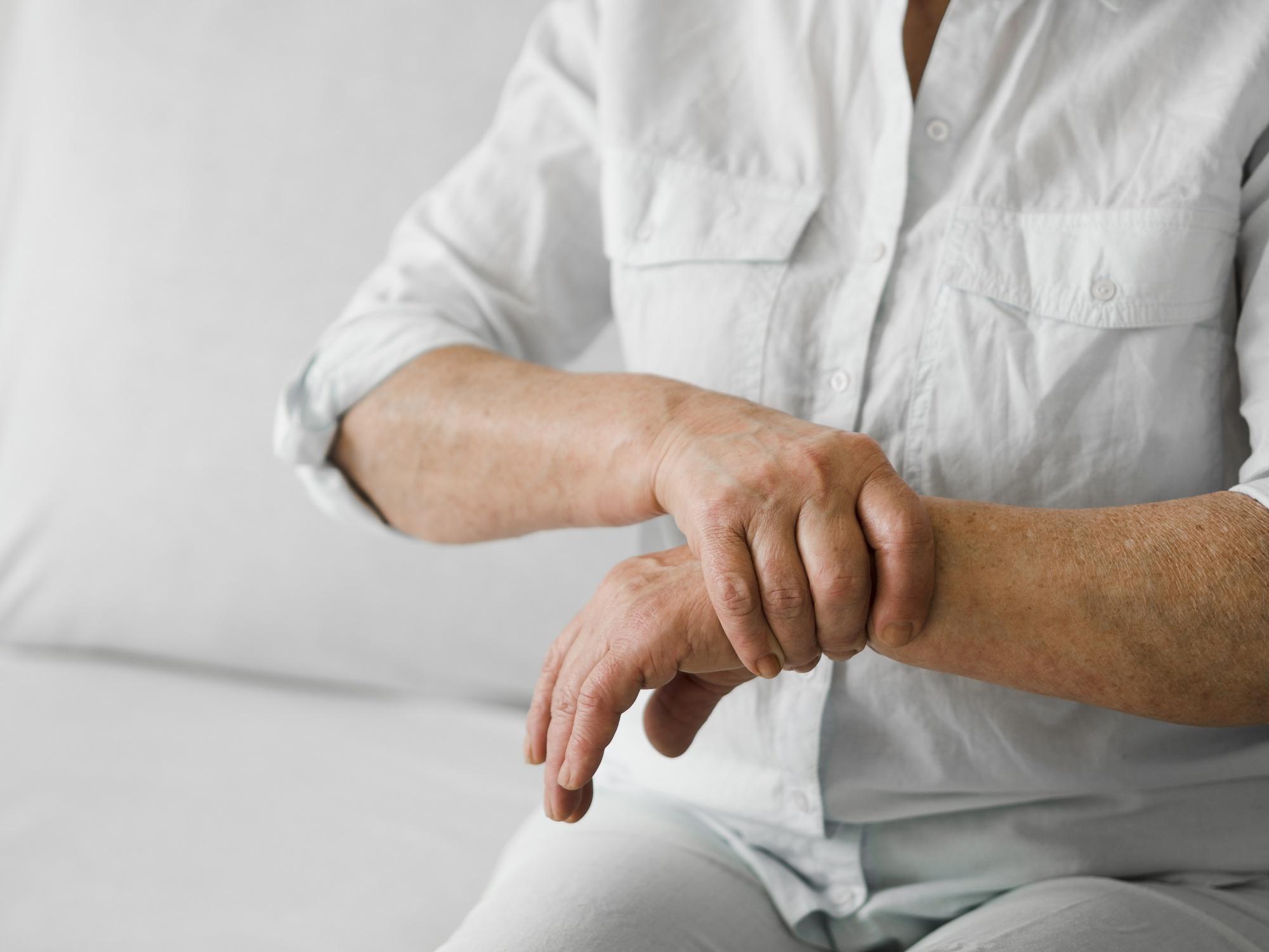 A person holding their wrist in discomfort, indicating bone pain.