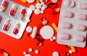 Different pills on a red surface 