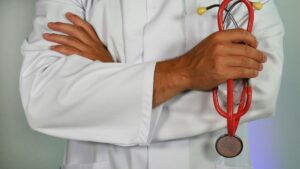 Medical professional with arms crossed holding a stethoscope