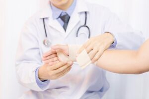 Doctor applying a gauze bandage to a patient’s hand