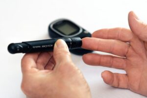 A glucose meter being used in a house. 