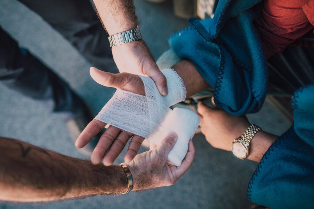 A person wrapping a bandage on another person’s hand.