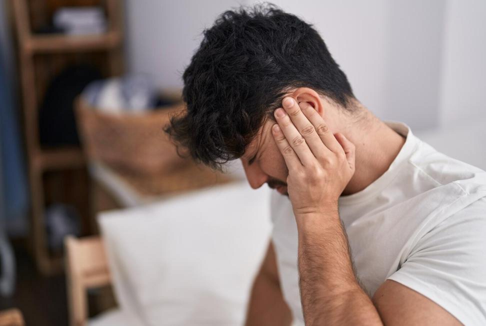 A man holding his ear in pain