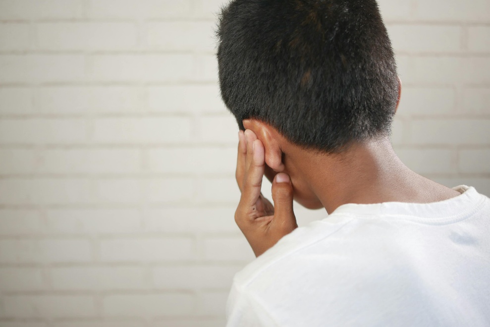 A child holding their ear in pain 