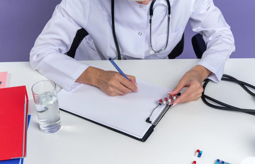 A close-up of a doctor writing a note. 