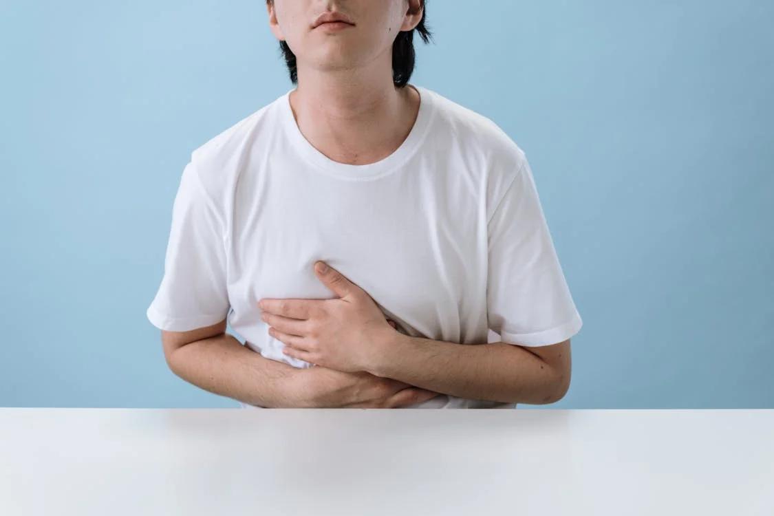 A boy clutching his stomach in visible discomfort, indicating the need for a legitimate doctor’s note
