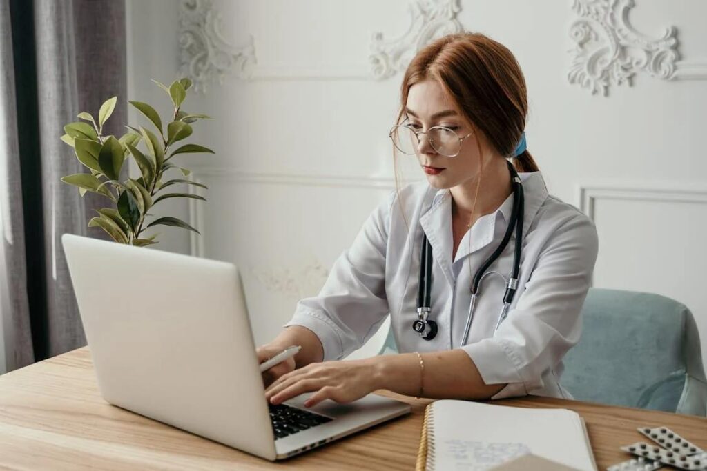 doctor typing on laptop
