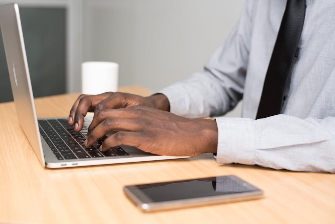  A professional  sitting at a desk typing a medical note into a laptop