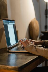 An image of a person typing on a laptop