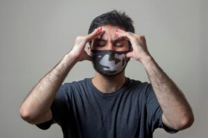 A man holding his head with his eyes closed