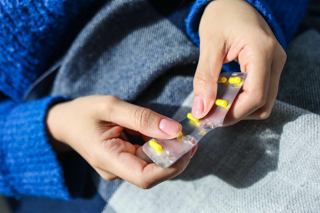 A woman at home taking medication and resting during her time off