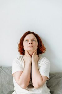 A person touching their neck