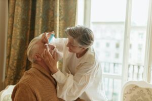 Caregiver using eye drops for relief from conjunctivitis symptoms