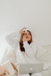 Woman applying drops at home to ease conjunctivitis symptoms