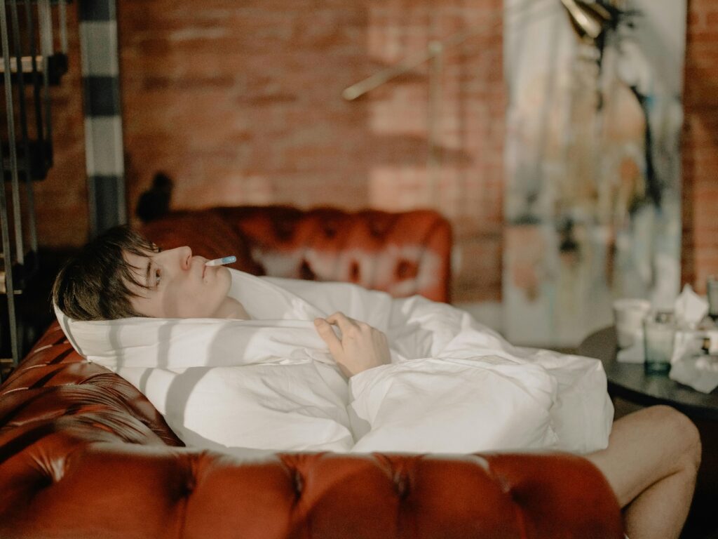 a person lying on a bed with a white blanket