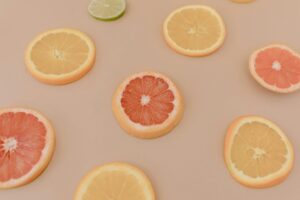 Mixed slices of grapefruit and oranges spread across a peach-colored background.