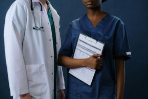 doctor in a white coat standing beside a nurse holding a clipboard