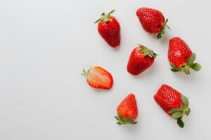 Fresh strawberries arranged on a white table.