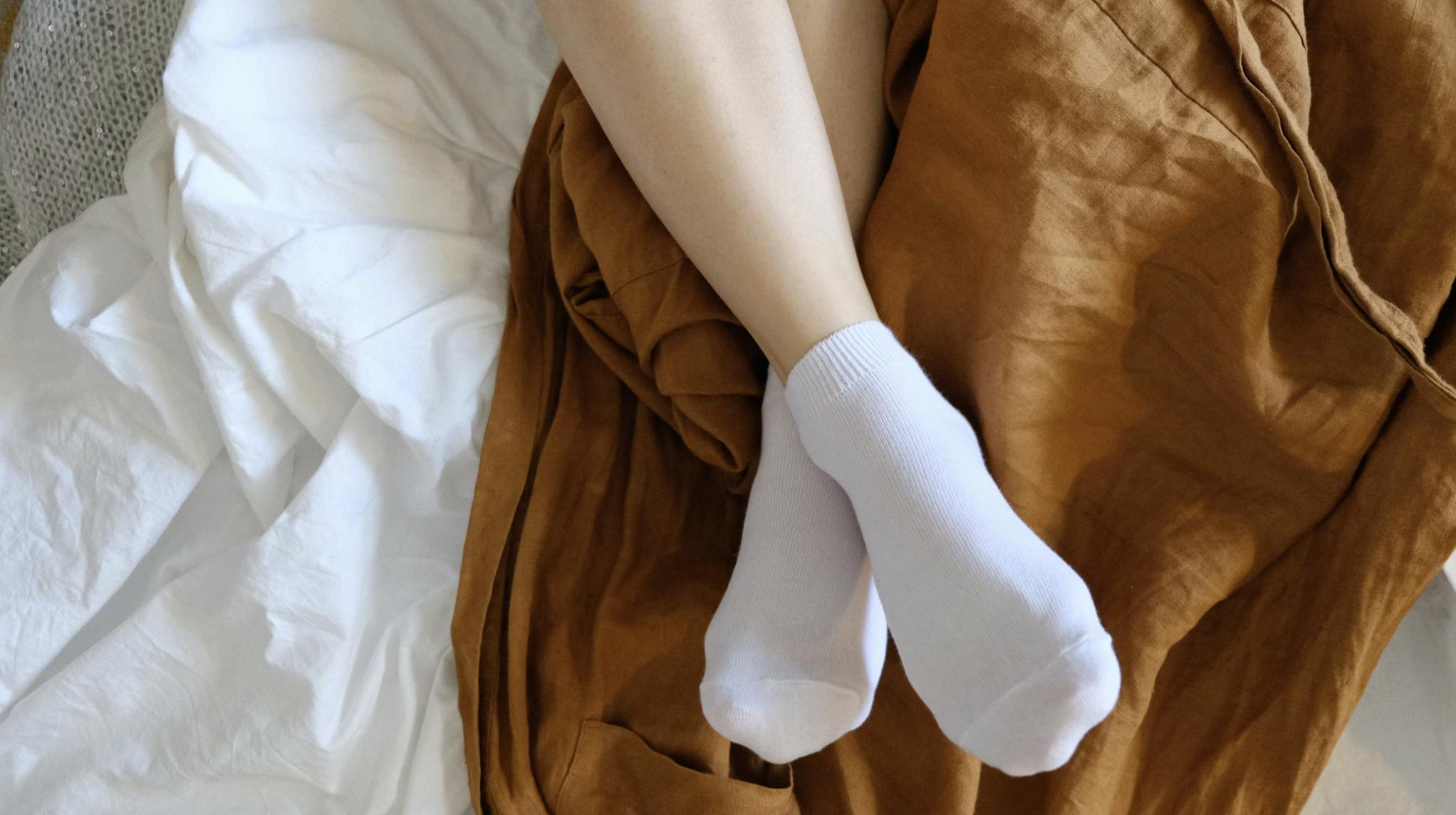 This photo shows a person resting feet comfortably on bed.