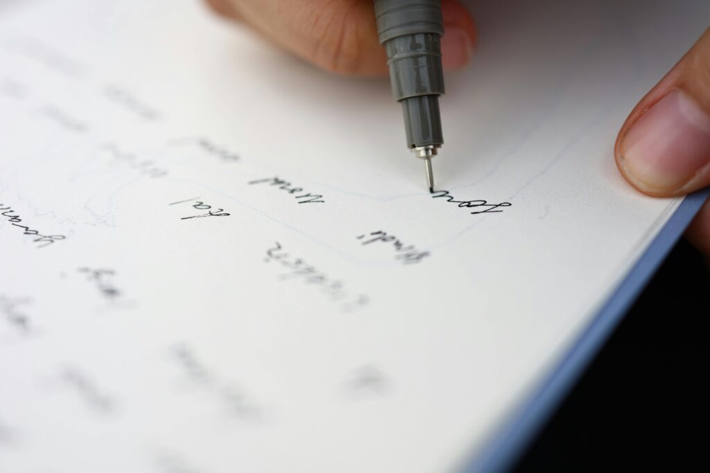a person writing a note with a pen