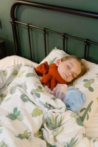 a woman sitting on the couch, looking sick.