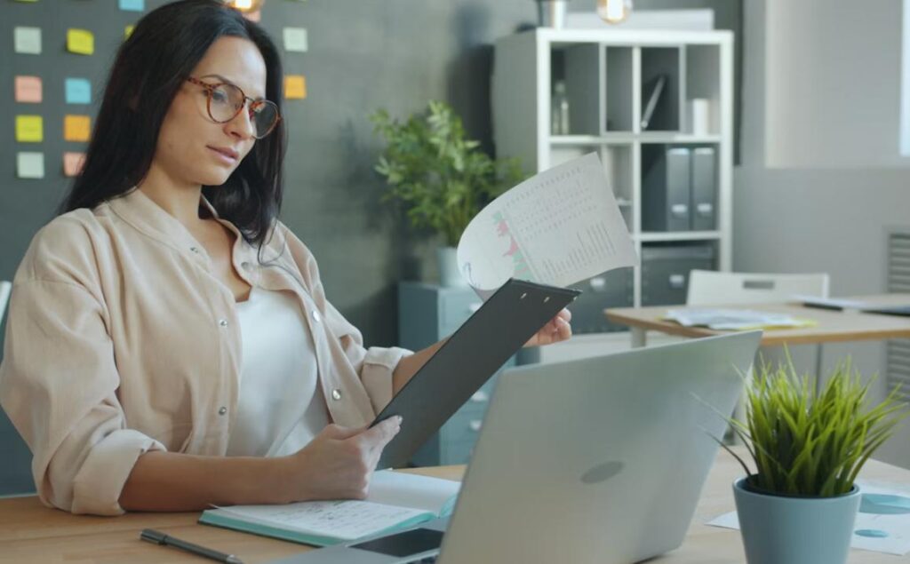 This image shows a lady reading a digital sick note on her laptop.