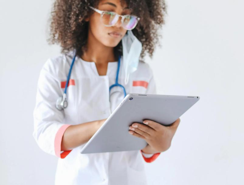 This image shows a doctor is reading an online application on her tablet.