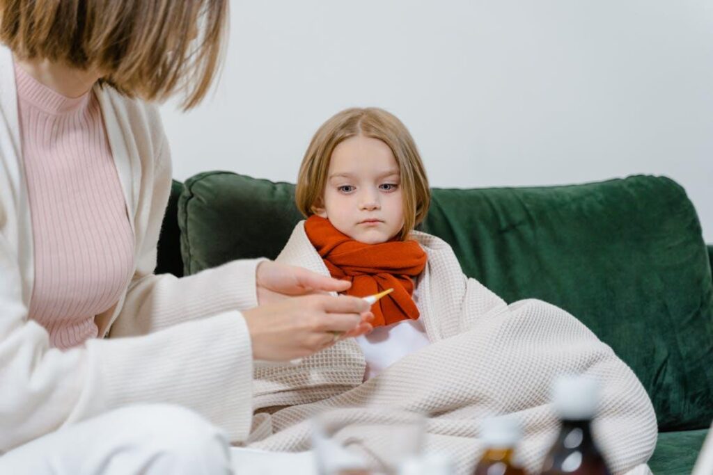 Parent checking a child’s temperature at home during a school absence.