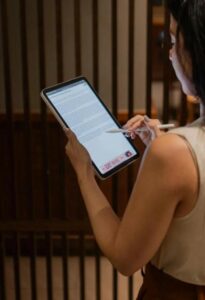 This image shows a woman reviewing a document on a tablet.