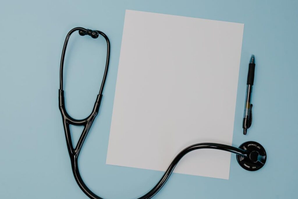 Black stethoscope placed on a white sheet of paper