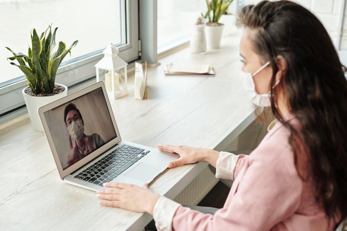 Remote employee attending a virtual doctor consultation on a laptop at home.